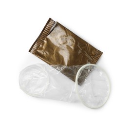 Photo of Unrolled female condom and torn package isolated on white, top view. Safe sex