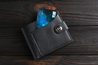 Photo of Credit card in leather wallet on wooden table, top view