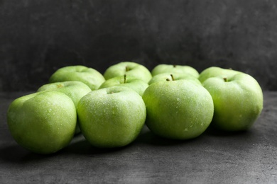 Fresh green apples with water drops on table