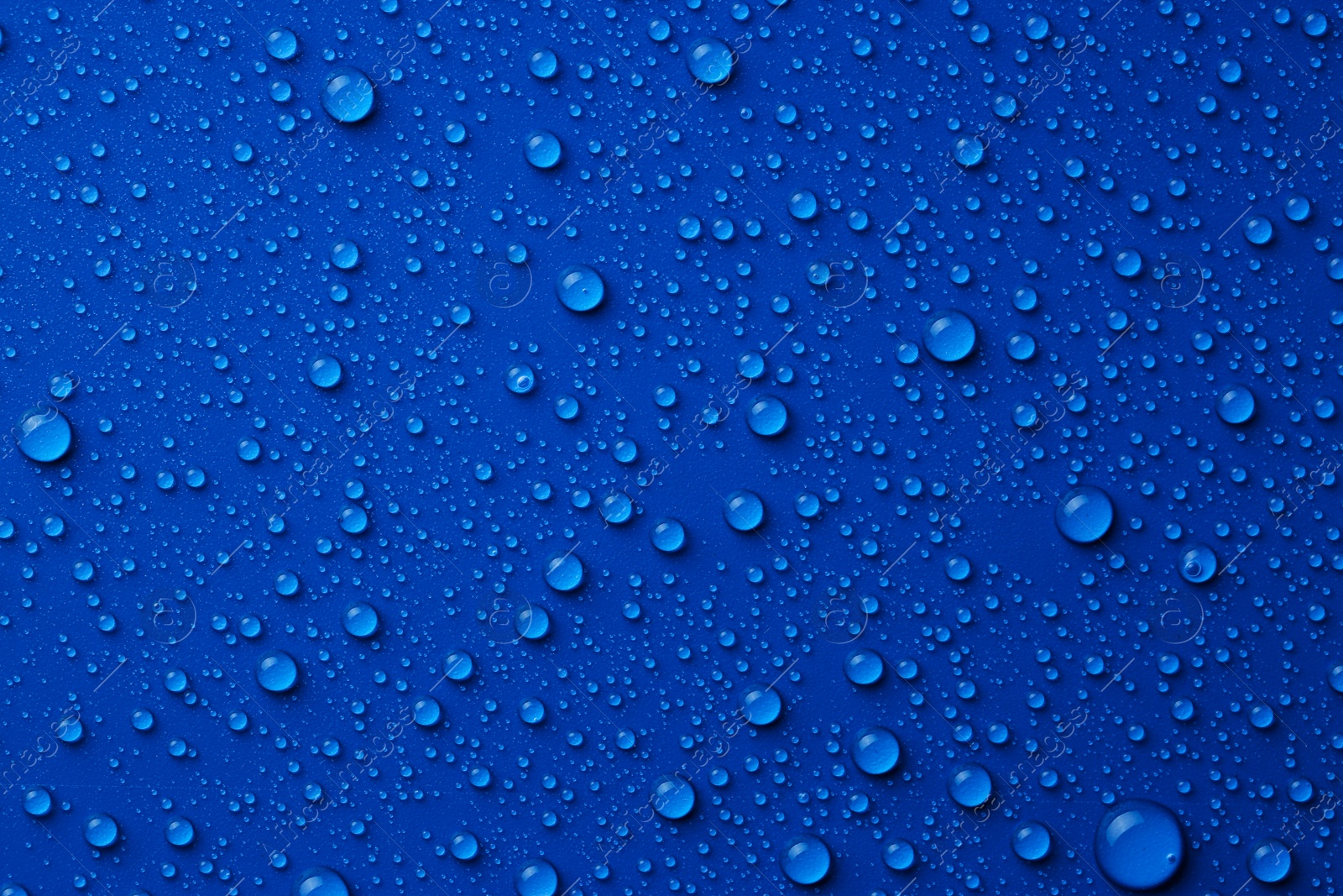 Photo of Water drops on blue background, top view