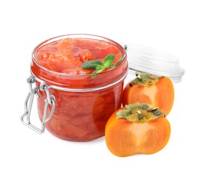 Jar of tasty persimmon jam and fresh fruits on white background