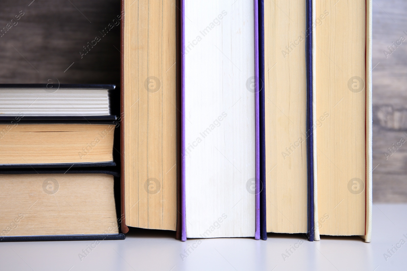 Photo of Collection of different books on white shelf, closeup
