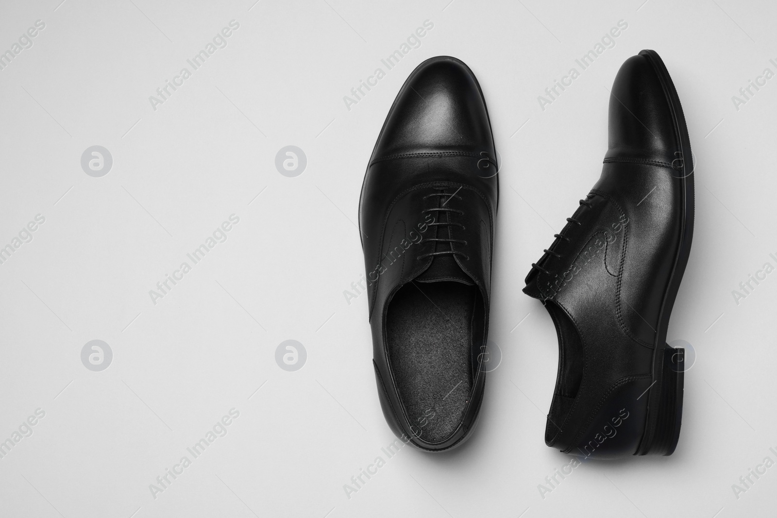 Photo of Pair of leather men shoes on white background, top view. Space for text