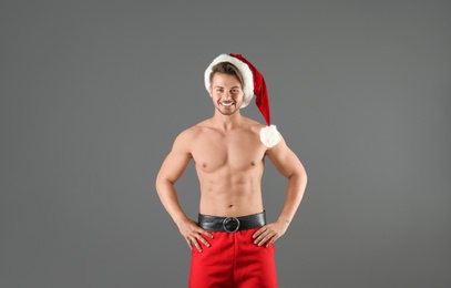 Shirtless young Santa Claus with sexy body on color background