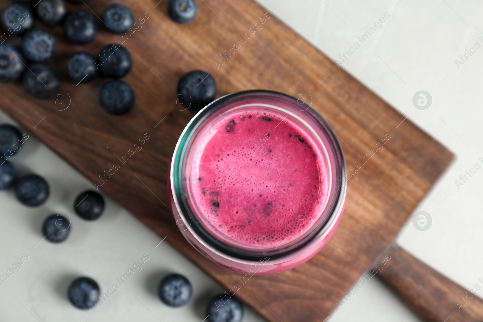 Photo of Jar with healthy detox smoothie and blueberries on table, top view