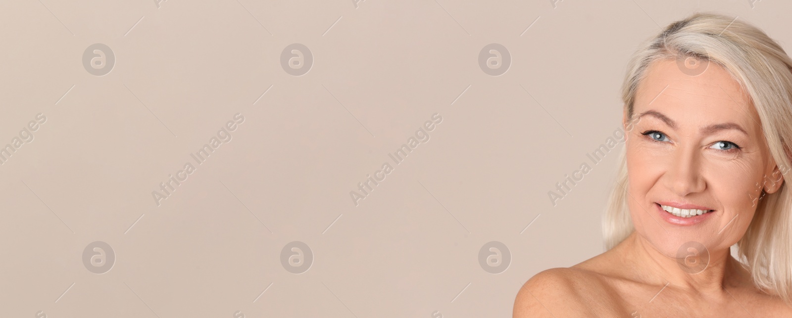 Image of Portrait of beautiful mature woman on beige background, space for text. Banner design