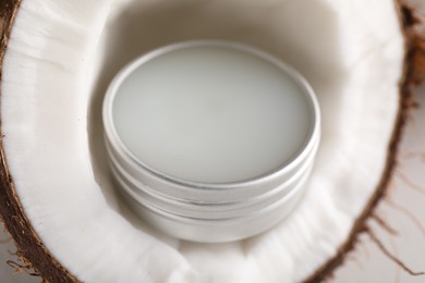 Photo of Lip balm inside coconut on white background, closeup