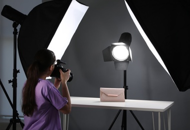 Photo of Professional photographer shooting stylish bag in studio