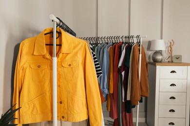 Photo of Racks with stylish clothes indoors. Fast fashion