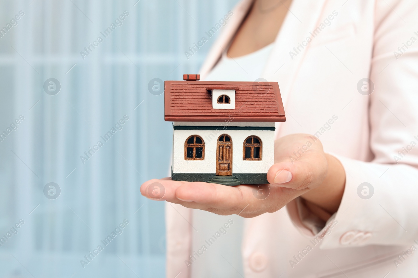 Photo of Real estate agent holding house model on blurred background