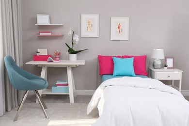 Modern teenager's room interior with comfortable bed and workplace