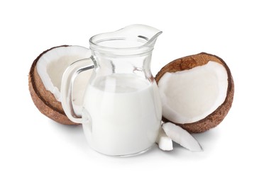 Photo of Glass jug of delicious vegan milk and coconuts on white background