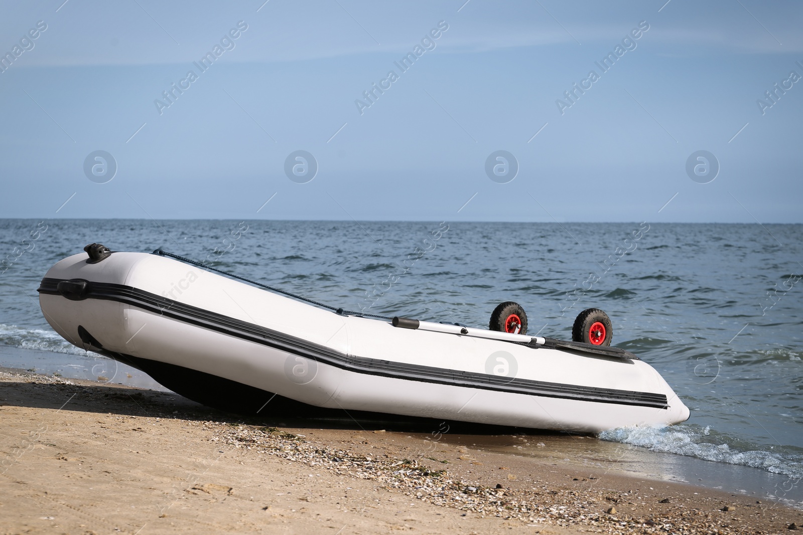 Photo of Inflatable rubber fishing boat on sandy beach near sea