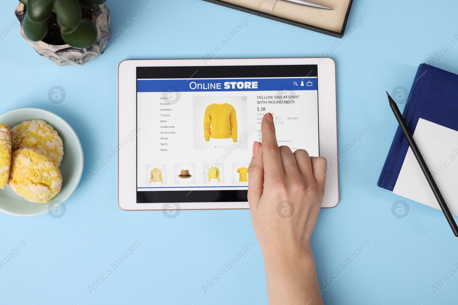 Photo of Woman with tablet shopping online on light blue background, top view