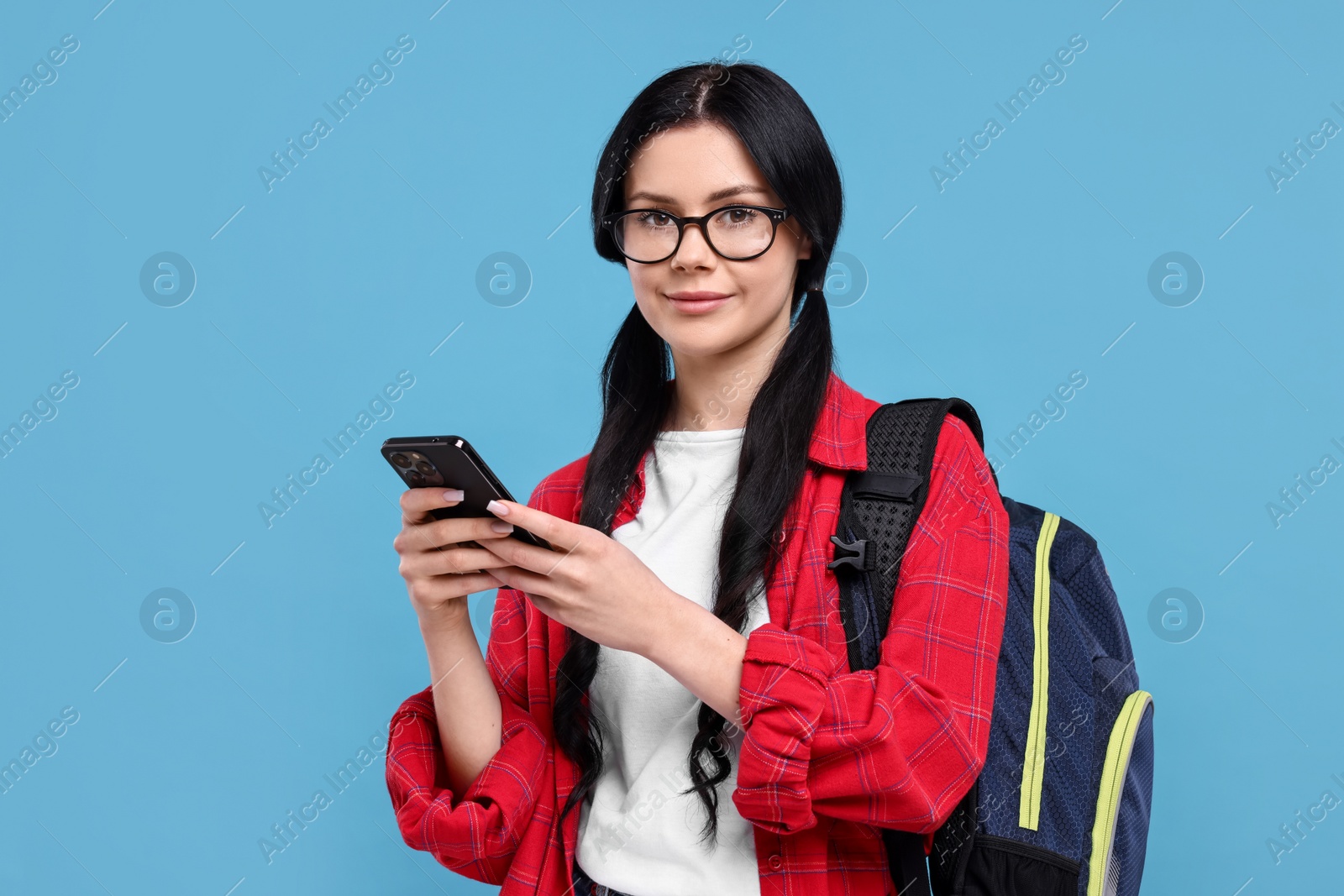 Photo of Student with smartphone on light blue background