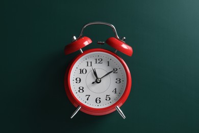 Alarm clock on green background, top view. School time