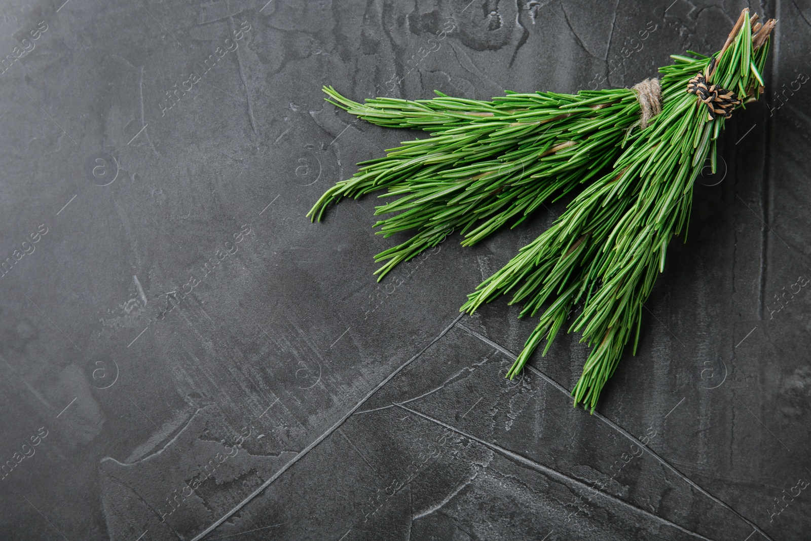 Photo of Bundle of fresh rosemary on grey background, top view. Space for text