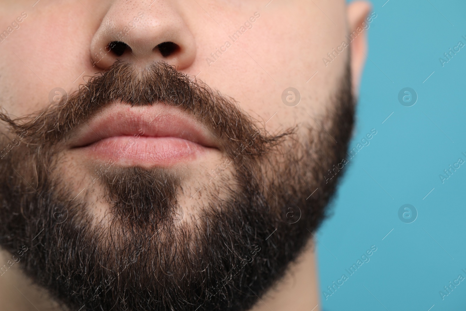 Photo of Man with mustache on light blue background, closeup