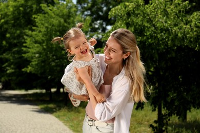 Happy mother with her daughter having fun in park