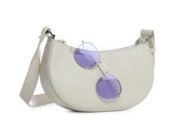 Stylish woman's bag and sunglasses isolated on white