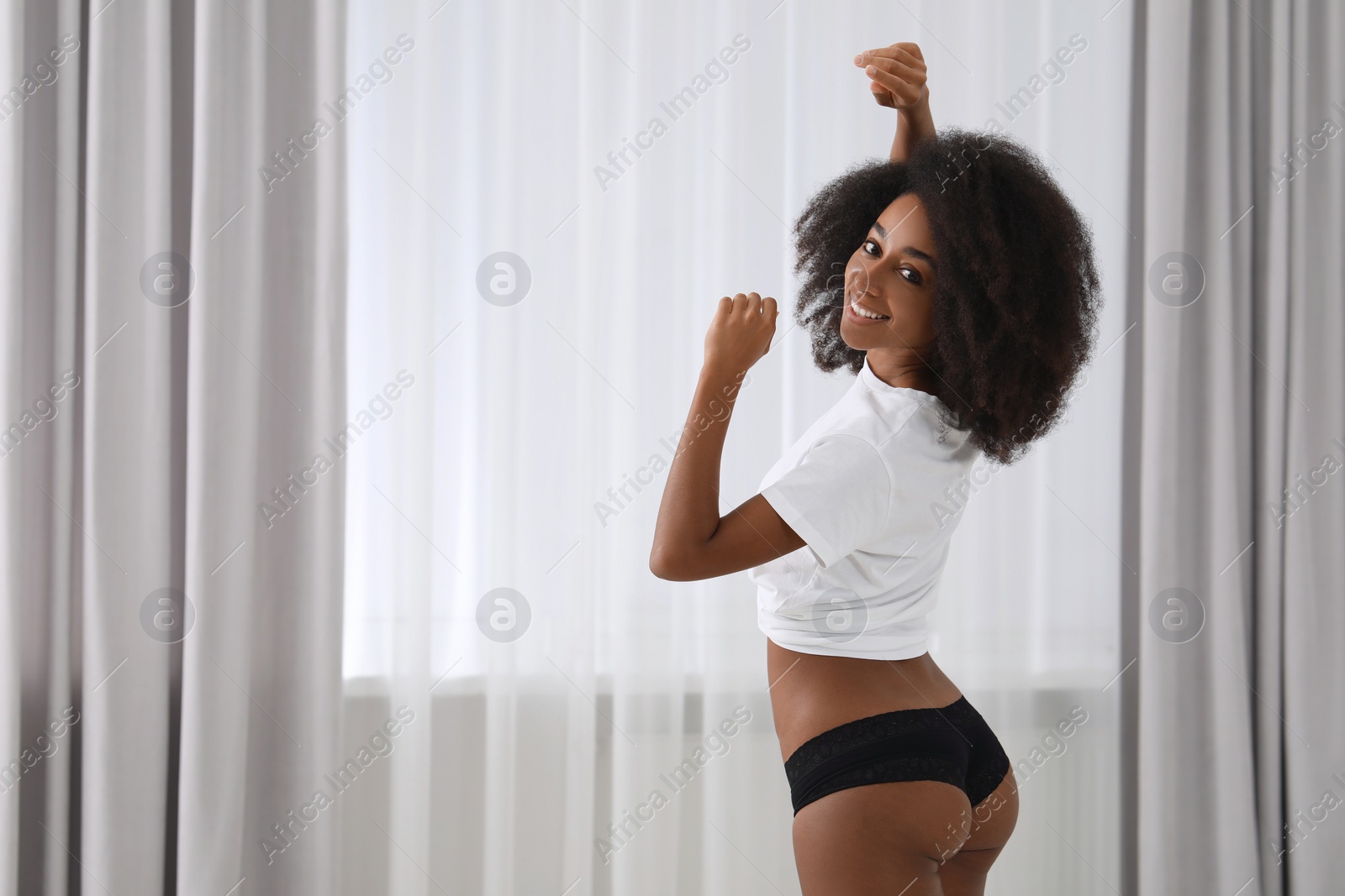 Photo of Beautiful woman in stylish underwear and t-shirt indoors, space for text