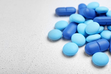 Photo of Blue pills on white background, closeup