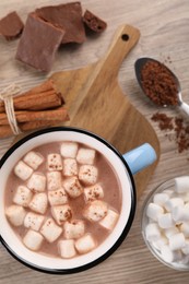 Cup of aromatic hot chocolate with marshmallows and cocoa powder served on table, flat lay