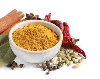Curry powder in bowl and other spices isolated on white