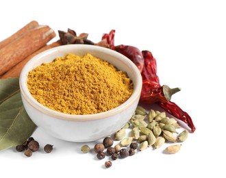 Photo of Curry powder in bowl and other spices isolated on white