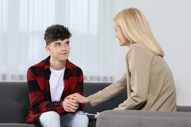 Photo of Psychologist working with teenage boy in office. Teenager problems