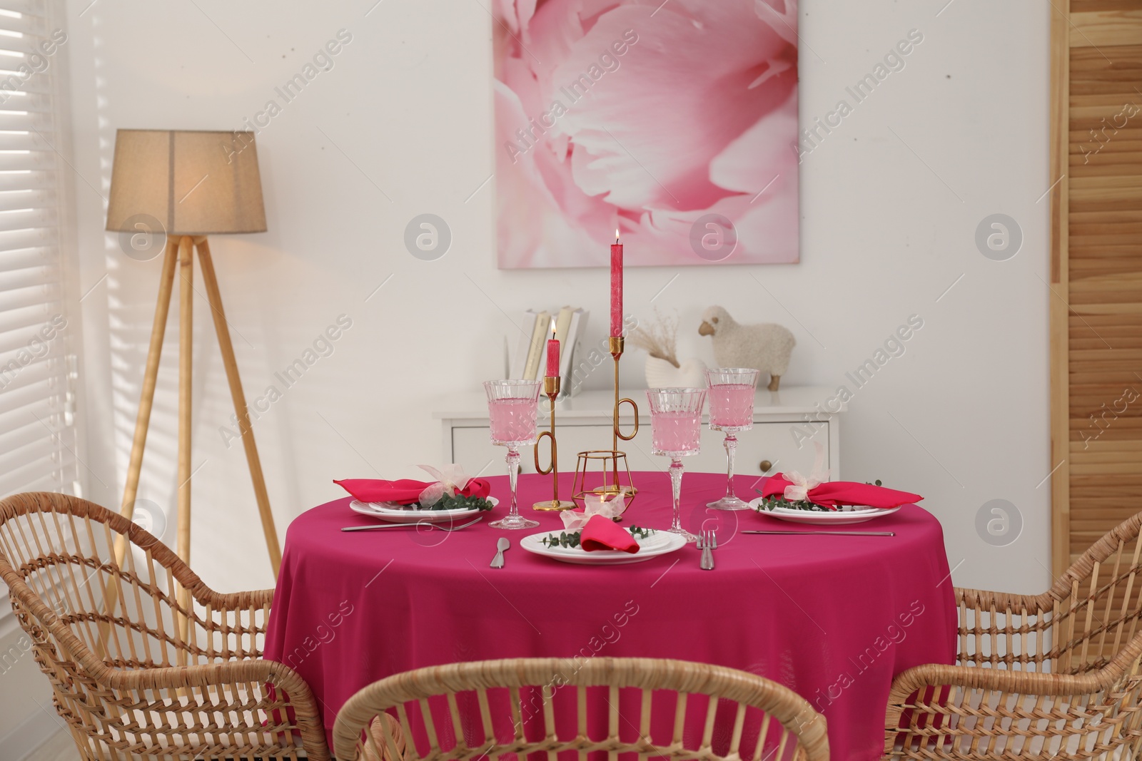 Photo of Beautiful table setting with green branches and burning candles in dining room