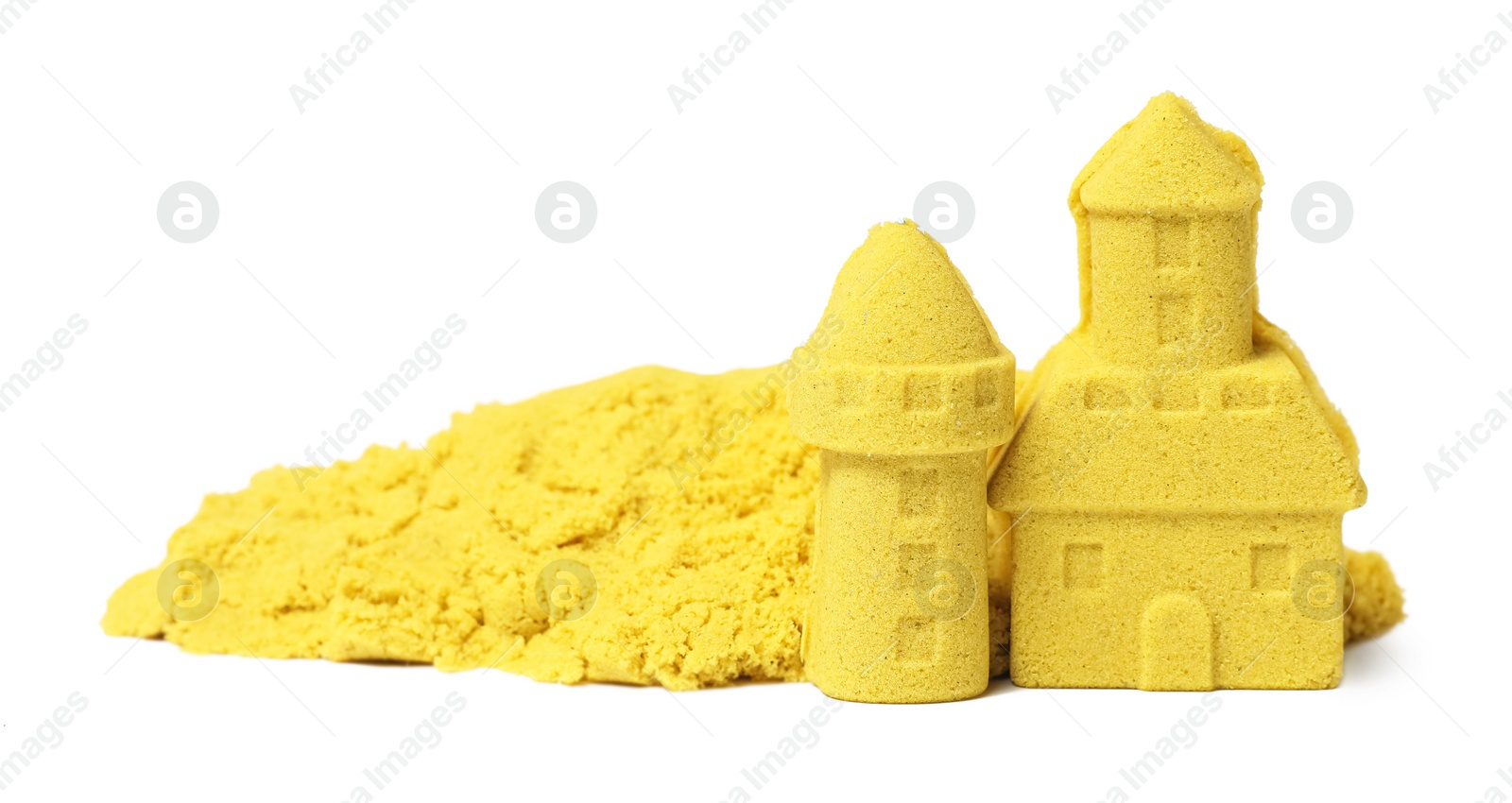 Photo of Castle and tower made of yellow kinetic sand isolated on white