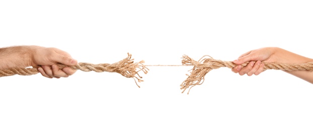 Man and woman pulling frayed rope at breaking point on white background