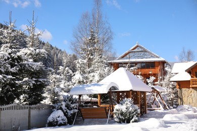 Photo of Picturesque view of wooden cabin and beautiful forest covered with snow in winter