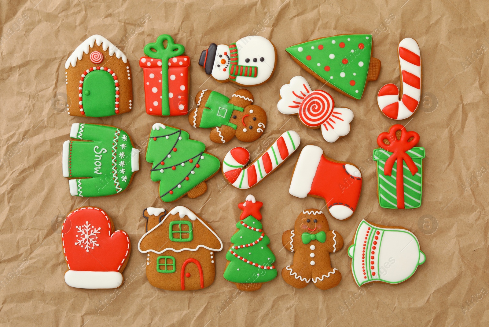 Photo of Different Christmas gingerbread cookies on crumpled parchment, flat lay