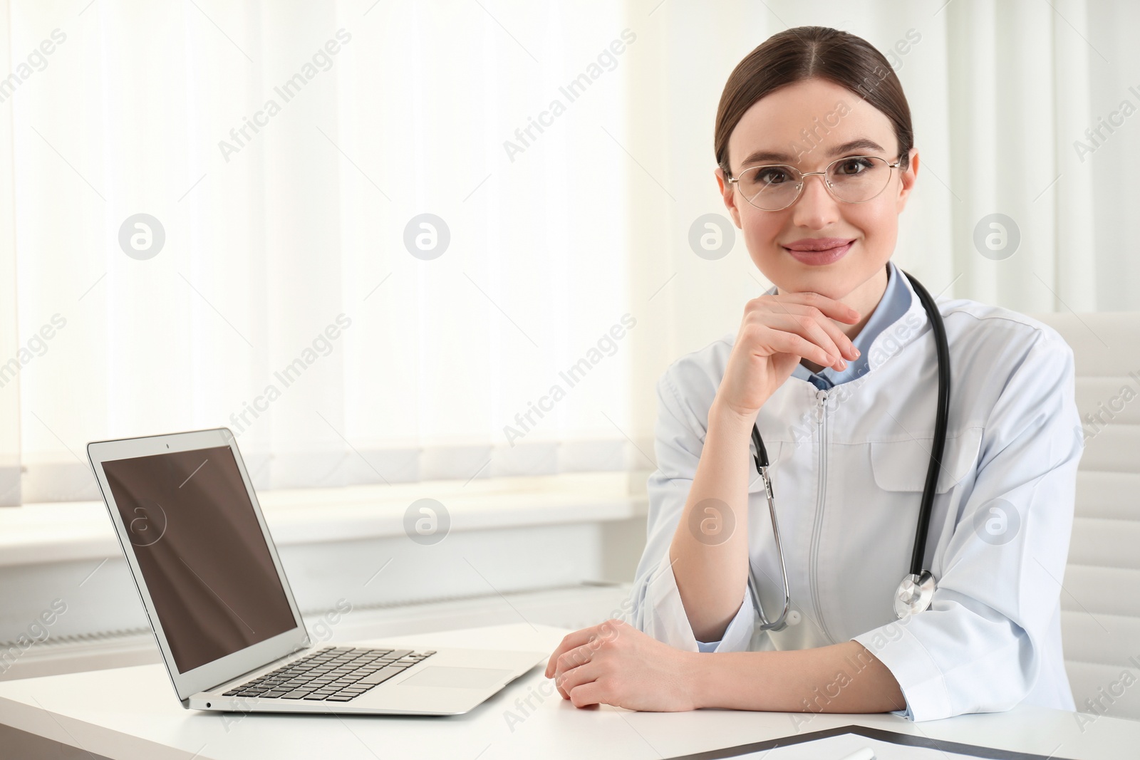 Photo of Portrait of young female doctor in white coat at workplace