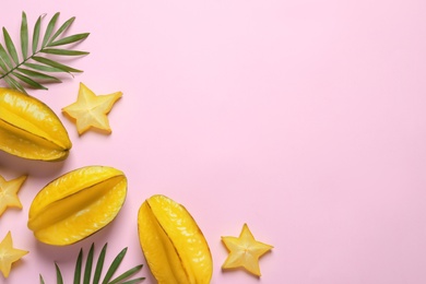 Photo of Delicious carambola fruits on pink background, flat lay. Space for text