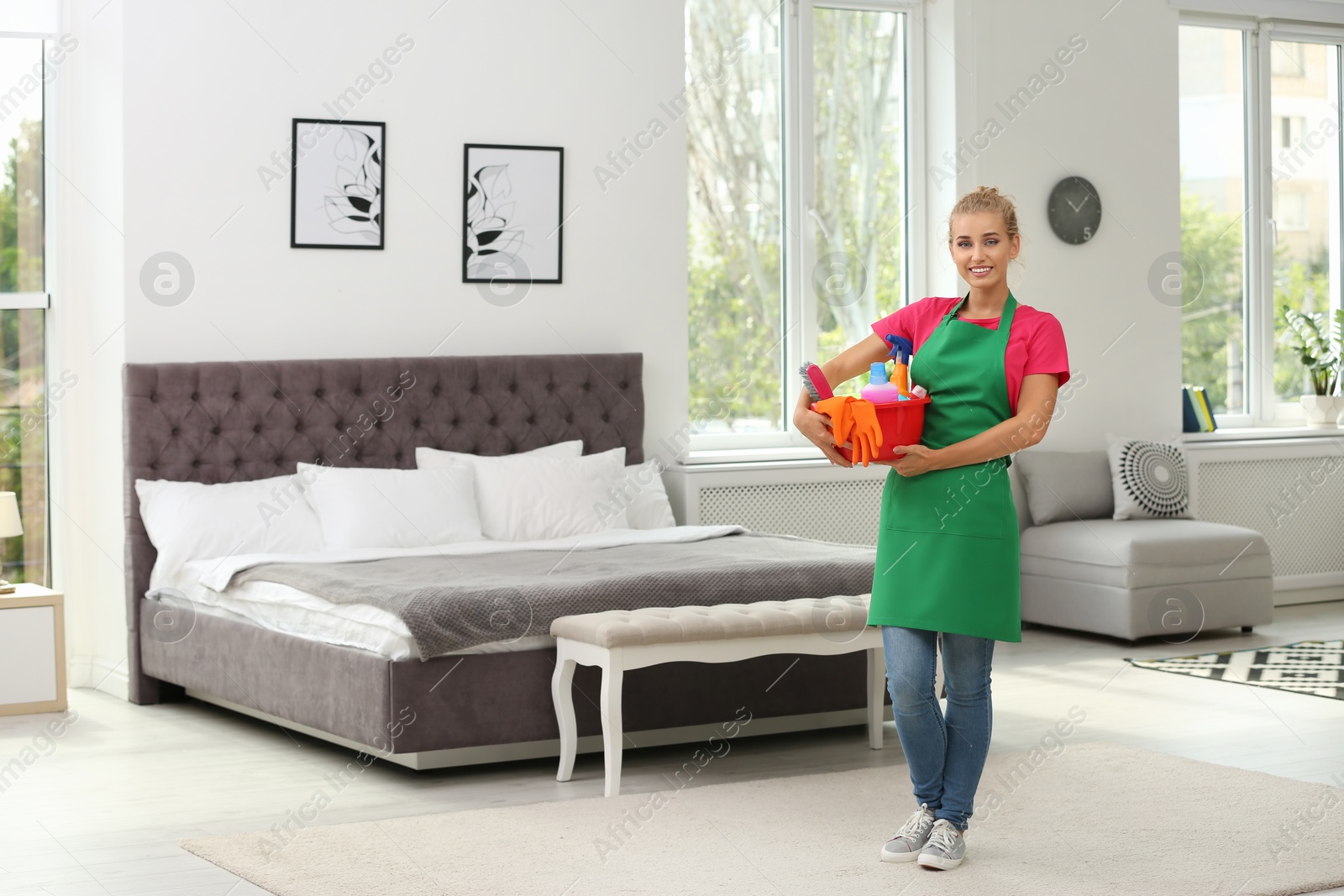 Photo of Woman with basin and cleaning supplies in bedroom