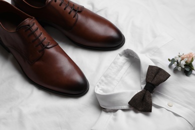Photo of Wedding shoes and shirt on white fabric