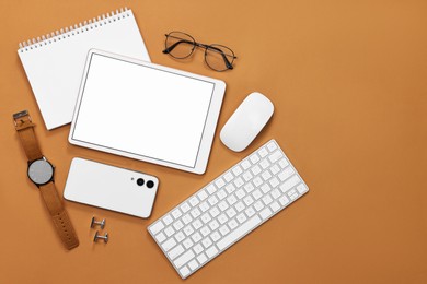 Flat lay composition with modern tablet on brown background. Space for text