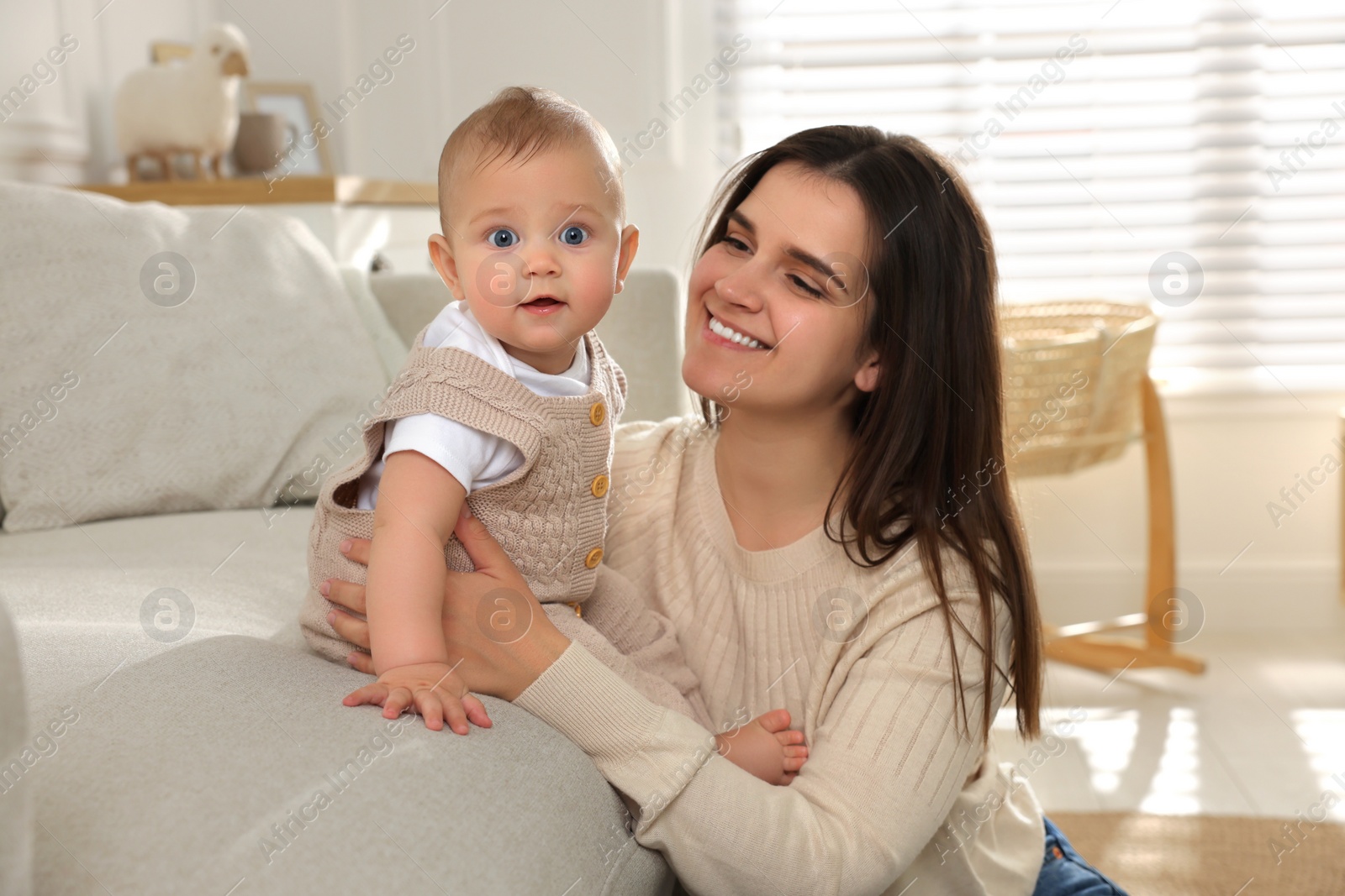 Photo of Happy young mother with her baby in living room