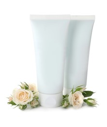 Tubes of hand cream and roses on white background