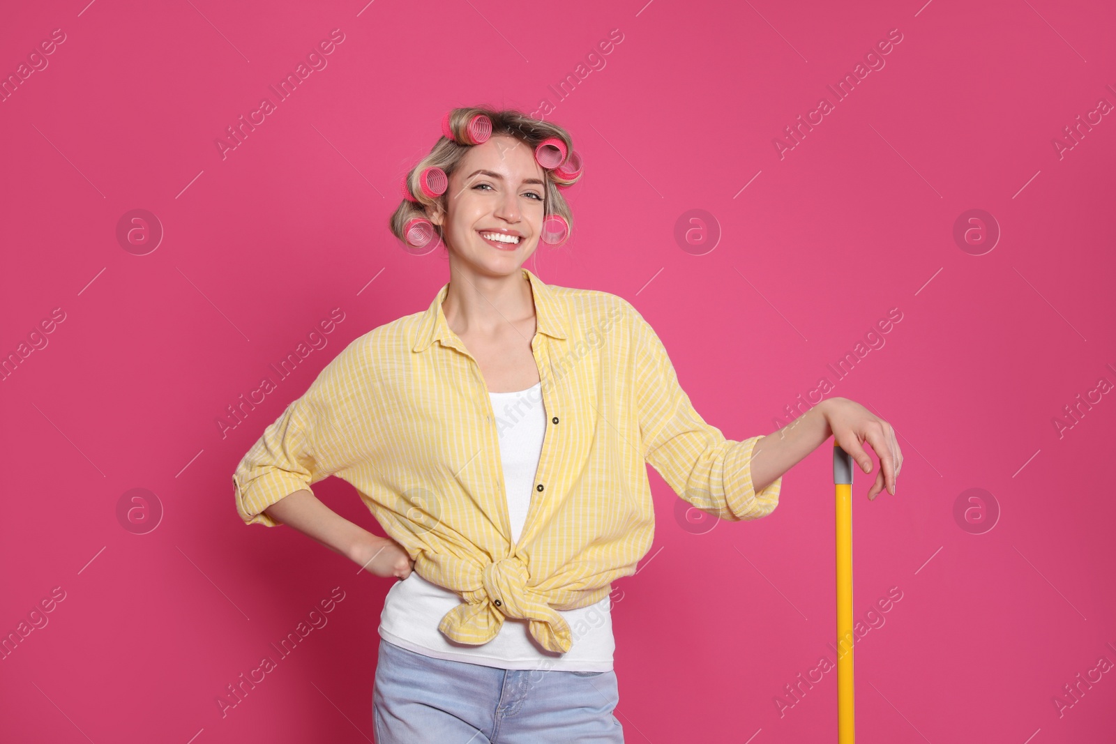 Photo of Young housewife with broom on pink background