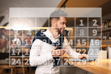 Image of Calendar and man working with laptop in cafe