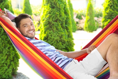 Man relaxing in hammock outdoors on warm summer day