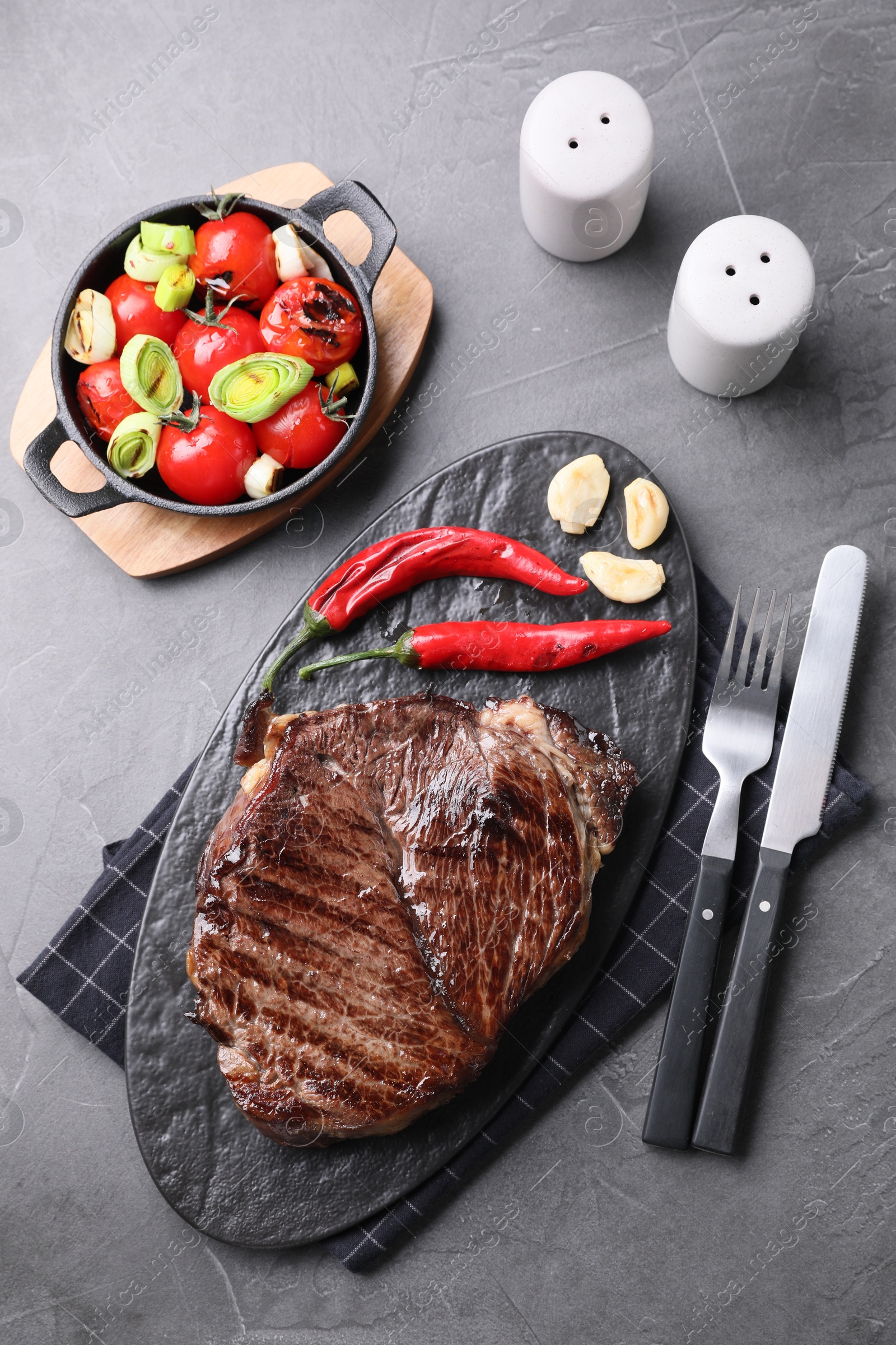 Photo of Delicious fried beef meat served on grey table, flat lay