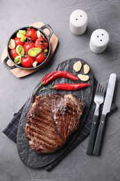 Photo of Delicious fried beef meat served on grey table, flat lay