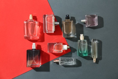 Photo of Perfume bottles on colorful background, flat lay