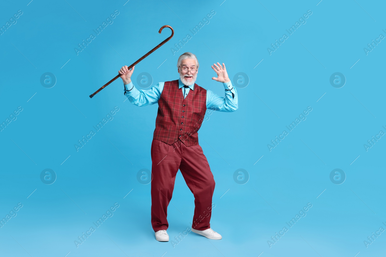 Photo of Emotional senior man with walking cane on light blue background