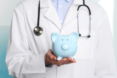 Photo of Doctor with piggy bank in hospital, closeup